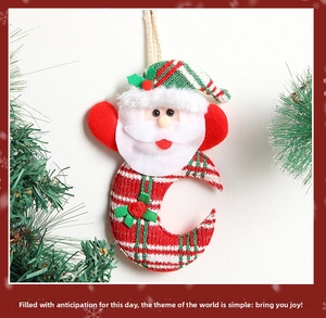 Detail of knitted Santa Claus moon pendant with festive red and green striped texture