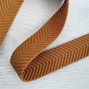 Makroaufnahme von jacquardgewebtem Schultergurt mit hellbrauner Fischgrätenstruktur