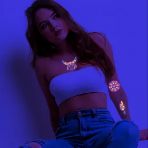UV fluorescent temporary tattoo with feather and bull head patterns glowing in neon light