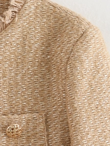 Detail of khaki tweed fabric with silver sequins and vintage gold metal button