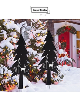 Detailed view of two black metal Christmas tree garden stakes with reindeer cutouts