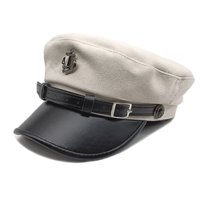 Detail of nautical sailor hat with white canvas, black leather visor and anchor badge