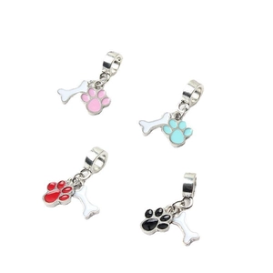 Detailed view of four colorful enamel cat paw and bone charms for charm bracelets