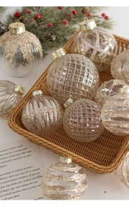 Champagne gold transparent Christmas balls with glitter patterns in a rustic basket