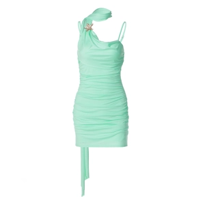 Detail of mint green bodycon dress featuring asymmetrical neckline and star brooch accessory