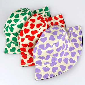 Detailed view of three cotton bucket hats featuring green, red and purple heart patterns