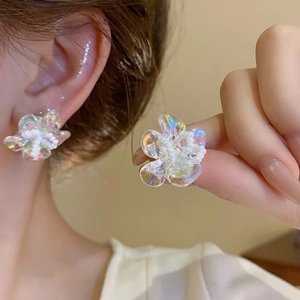 Close-up of translucent resin flower earrings with pearlescent finish and bead details