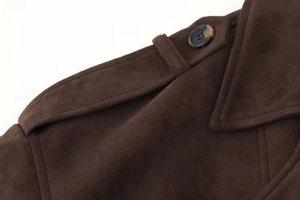 Détail de la veste en daim marron foncé avec bouton marbré et texture ultra douce