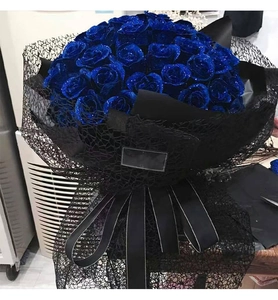 Detail of blue glitter roses wrapped in black hollow jacquard mesh and silk ribbon
