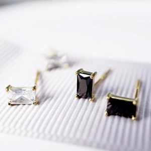 Macro view of rectangular multi-color cubic zirconia earrings on purple silk