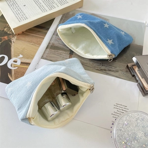 Detail view of denim star print makeup pouches with zipper closure and soft inner lining