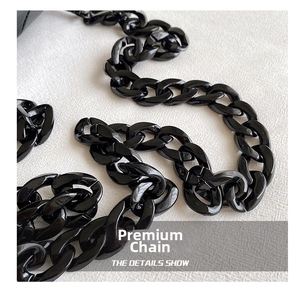 Close-up of high-gloss black acrylic chunky chain strap for crossbody doll bags