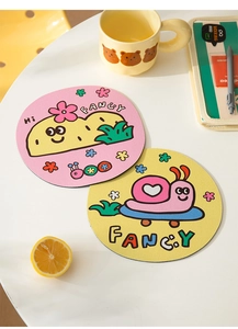 Detail view of round diatom mud coasters with cute pink and yellow cartoon patterns