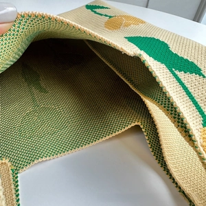 Close-up of knitted sunflower tote interior showing dense texture and floral craft