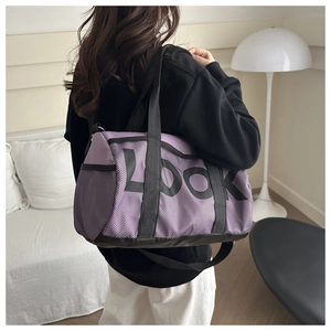 Detailed view of the large purple cylinder sports bag with mesh overlay on a model