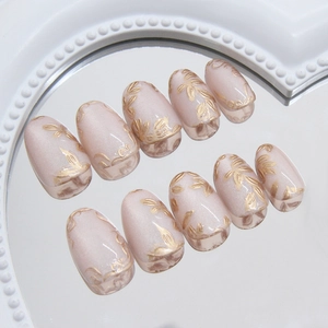 Pink pearl cat-eye press-on nails with 3D gold floral relief in oval shape