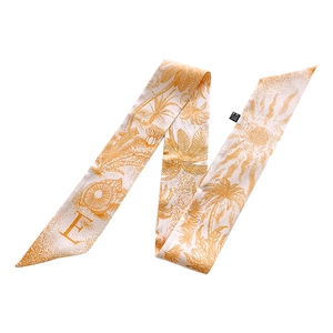 Close-up of silk letter E twilly scarf with tropical print and sun patterns