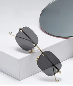 Detailed view of frameless square sunglasses with gold metal hinges and side C-decorations