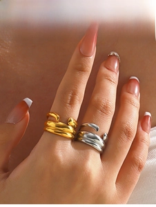 Detail of chunky gold and silver layered open rings in a minimalist wrap design