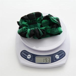 Detail shot of green plaid fabric scrunchie on electronic scale showing weight of 19.3g