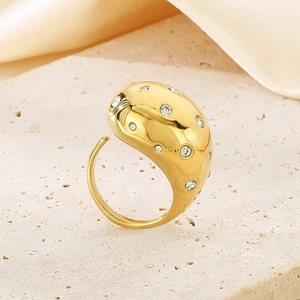 Detailansicht eines massiven 18K vergoldeten Rings mit Diamanten auf Steinhintergrund