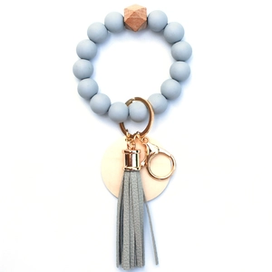 Detail of grey silicone beads, hexagonal wood bead, and leather tassel on keychain