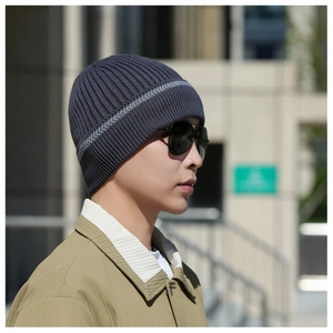Outdoor shot of man wearing navy striped knit beanie with ribbed texture for winter warmth