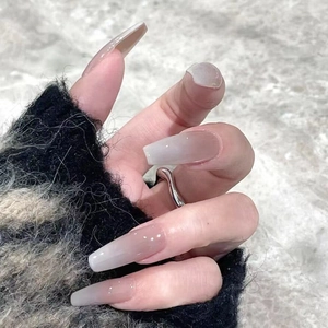 Detailed close-up of long coffin-shaped press-on nails with pink and white ombre gradient finish