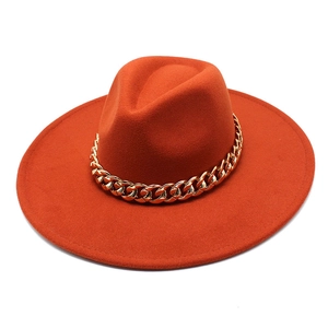 Close-up of caramel wide brim fedora hat featuring a chunky gold chain band detail