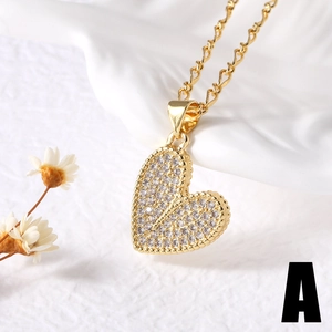 Golden heart pendant necklace with white cubic zirconia on white silk background