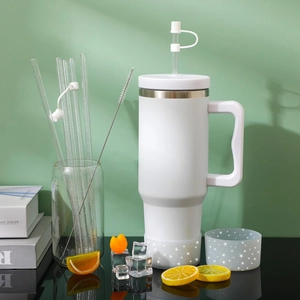 White stainless steel tumbler with straw cover, silicone boot, and cleaning brush kit