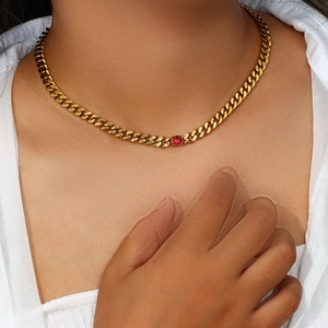 Detail of 18K gold-plated 6.5mm curb chain necklace featuring a brilliant red zircon stone