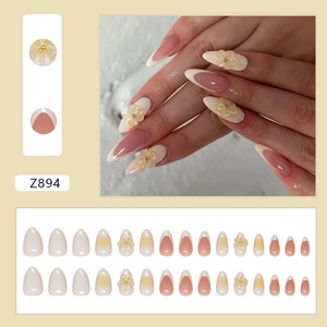 French press-on nails in nude pink with white tips and 3D yellow floral accents