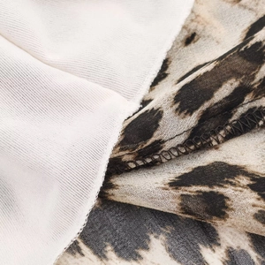 Dettaglio del tessuto in chiffon leopardato e fodera in maglia bianca sul vestito senza maniche
