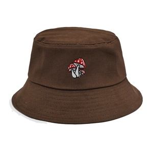 Close-up of brown canvas bucket hat featuring detailed red and white mushroom embroidery
