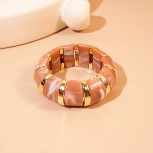 Macro shot of geometric acrylic marble segments and gold metal link detailing