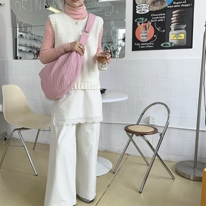 Lifestyle shot of large pink crescent crossbody bag with pleated texture on model