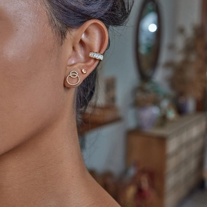 Elegant gold earrings with sparkling pear-cut gems and interlocking crystal circles on model