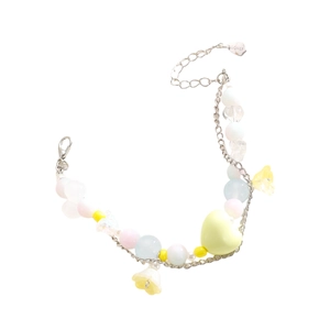 Detalle de pulsera de cuentas macarrón con dije de corazón amarillo y flor pequeña