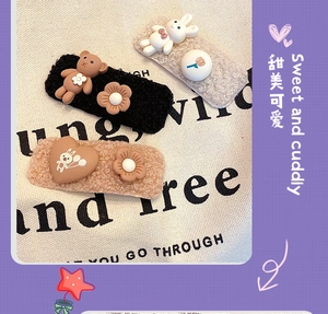 Detail of plush lamb wool hair clips featuring cute cartoon bear and rabbit designs