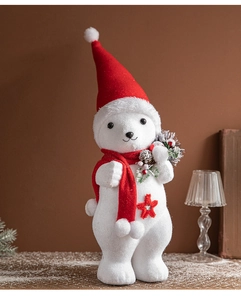Detail of a white plush Christmas bear figurine wearing a red hat and scarf with pine cones