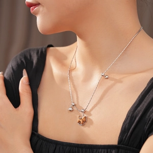 Détail d'un collier avec pendentif cheval en bois et cloches sur un mannequin