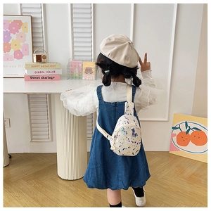 Rear view of unicorn print crossbody chest bag on a child wearing denim overalls