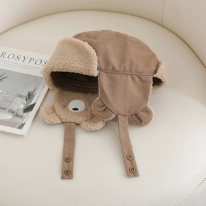 Detailed close-up of brown plush bear ear flap hat with soft faux lamb wool lining