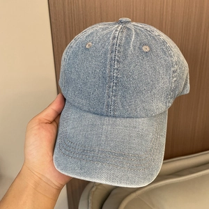Close-up of light blue washed denim baseball cap showing fabric texture and stitching