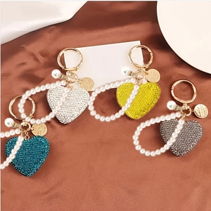 Dettaglio di portachiavi a cuore con strass in blu, argento, giallo e grigio scuro