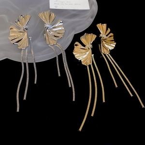 Detail of silver and gold ginkgo leaf tassel earrings with long metallic snake chains