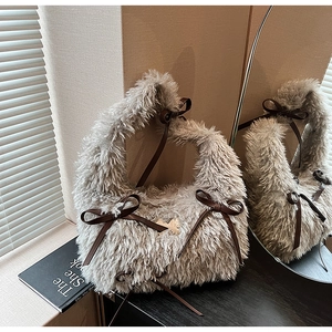 Detail of plush taupe faux fur handbag featuring dark brown leather bow accents and textures