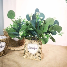 Detail of artificial eucalyptus and baby's breath in a heart woven basket