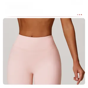 Détail de la taille haute compressive sur le pantalon évasé de yoga rose